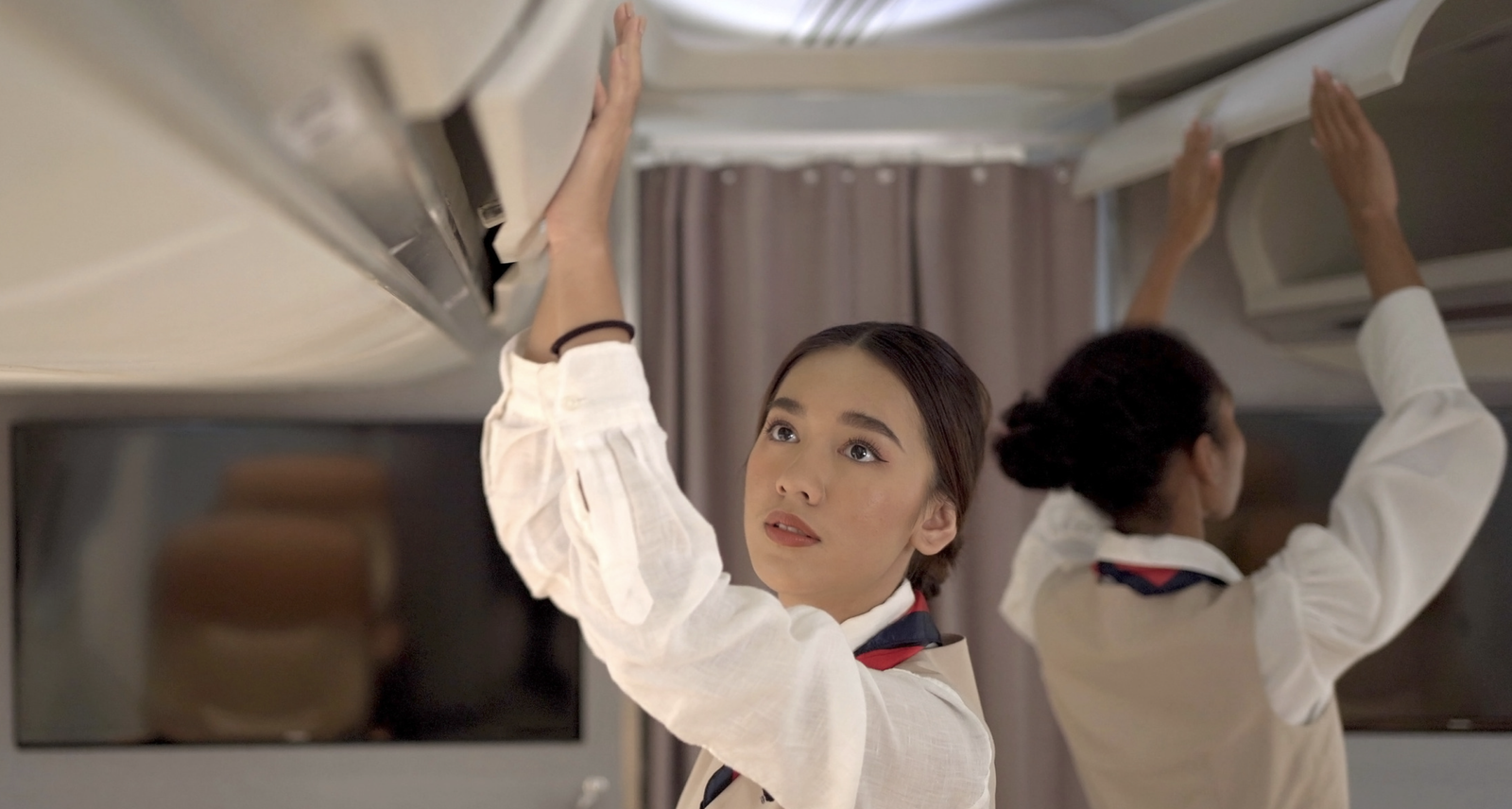 asian air hostesses, cabin crew closing cabin compartments