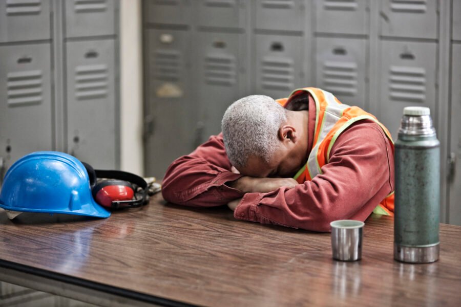 Black man factory worker taking a break from work in a factory locker room. Crew Wellbeing