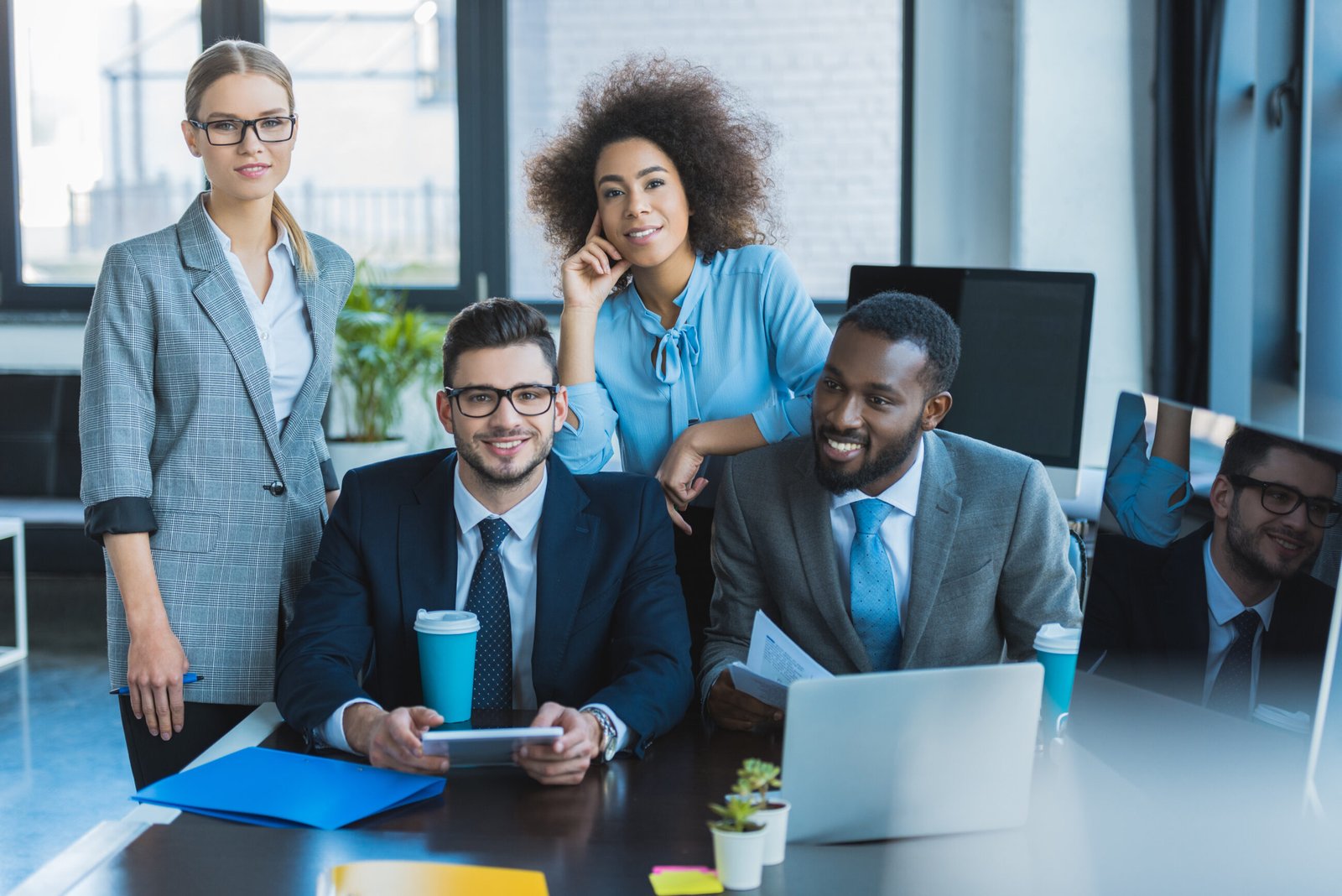 smiling multicultural businesspeople looking at camera in office. Crew Wellbeing