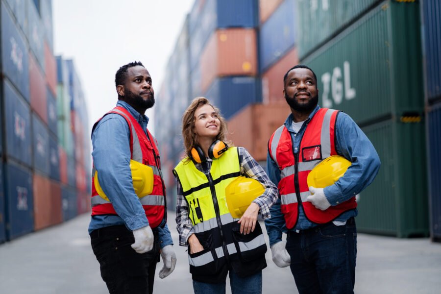 portrait engineer technician confident diverse workers Wear a safety helmet Cargo container background. Industrial transport and logistics concept. teamwork concept. Workforce Resilience.