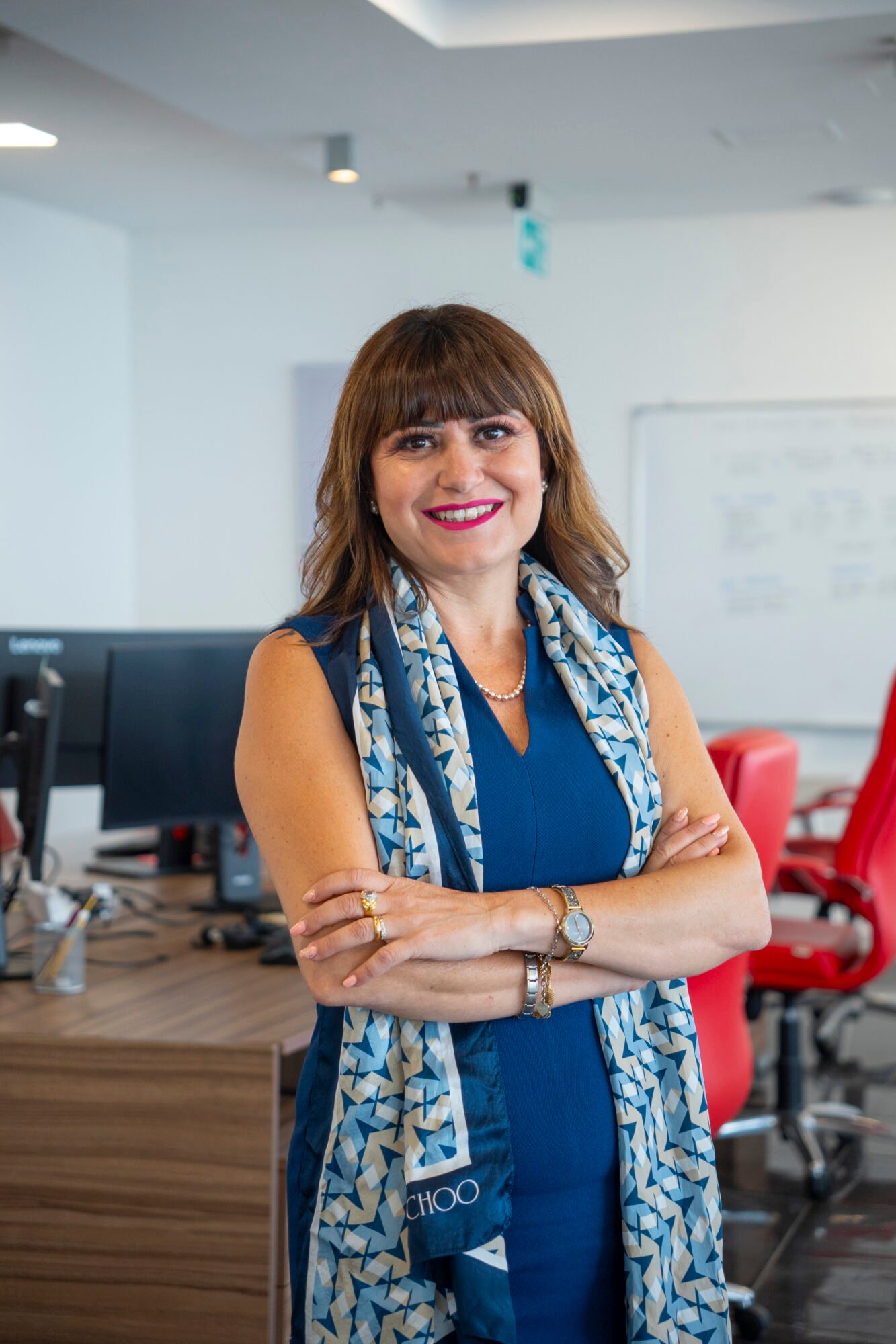 Giovanna Mirabile standing with her arms crossed in an office, smiling at the camera. Workforce Governance in Malta.