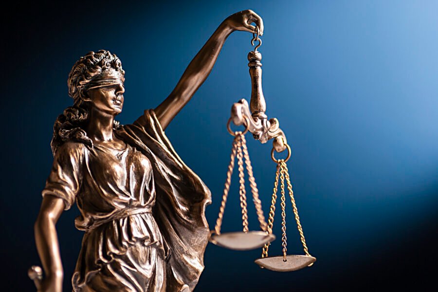 Lady Justice statue holding balanced scales, representing employment law, fairness, and legal rights in the workplace. Legal terminations in Malta.