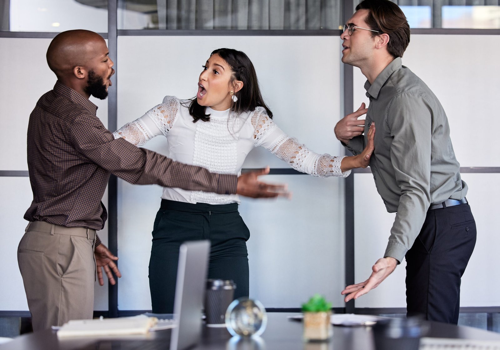 Three colleagues having a discussion in a modern office.
