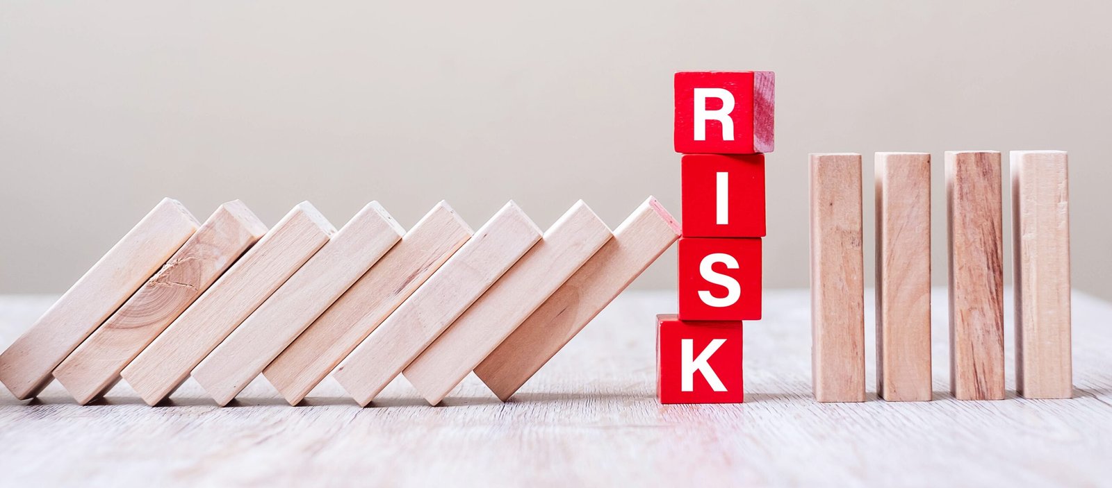 Wooden dominoes arranged to illustrate business risk and prevention.